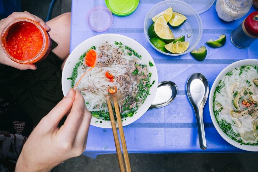 Món ăn ở chợ thường được phục vụ tại một “quán di động” với những chiếc bàn ghế nhựa giản dị, tạo nên nét đặc trưng riêng của ẩm thực đường phố Hà Nội (Nguồn: Freepik)